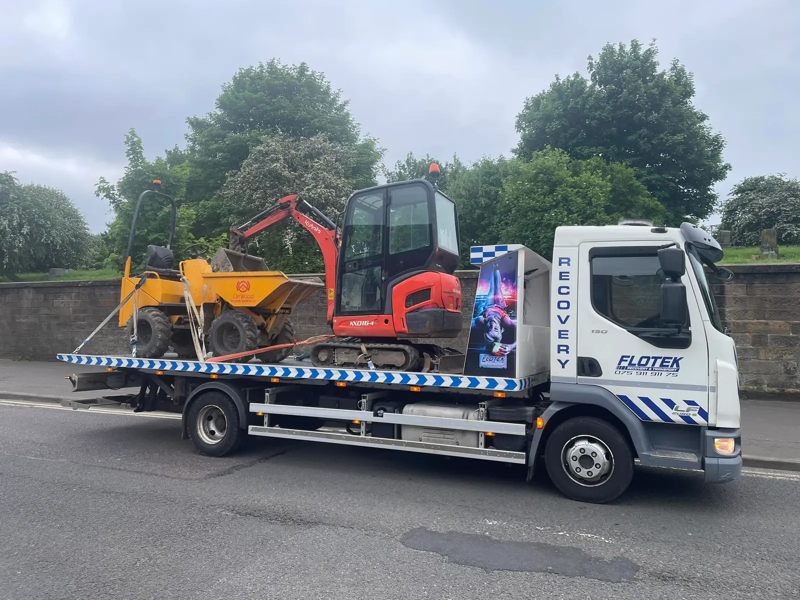 Flotek recovery truck transporting a dumper and compact excavator